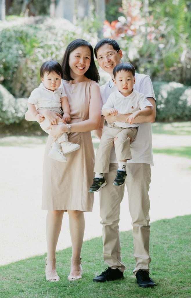Candid outdoor family photoshoot with parents and two kids during a playful moment